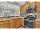 This kitchen features stainless steel appliances, granite countertops, mosaic backsplash, and wood cabinetry at 520 Brier Crossings Loop, Durham, NC 27703