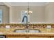 Granite countertops meet a double basin sink with bronze fixtures and mosaic backsplash in this bright, modern kitchen at 520 Brier Crossings Loop, Durham, NC 27703