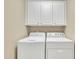 Well-lit laundry room with a washer, dryer, and overhead storage cabinets at 520 Brier Crossings Loop, Durham, NC 27703