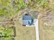 An aerial shot shows a home with a long driveway, lush lawn, and surrounding trees at 62 Narmada Ct, Zebulon, NC 27597