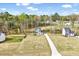 A home on a large lot with a long driveway, surrounded by trees and other homes in the neighborhood at 62 Narmada Ct, Zebulon, NC 27597