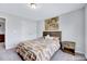 Bright bedroom featuring a wooden bed frame, patterned bedding, and neutral walls with a side table at 62 Narmada Ct, Zebulon, NC 27597