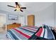 Comfortable bedroom showcasing a ceiling fan, wall-mounted television, and ample storage with a modern wardrobe at 62 Narmada Ct, Zebulon, NC 27597