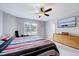 Spacious bedroom featuring a ceiling fan, large window, and sleek dresser with a wall-mounted television at 62 Narmada Ct, Zebulon, NC 27597