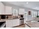 Well-lit kitchen featuring white cabinets, granite countertops, stainless steel appliances, and modern fixtures at 62 Narmada Ct, Zebulon, NC 27597