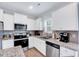 Well-equipped kitchen featuring granite counters, stainless steel appliances, and ample white cabinetry at 62 Narmada Ct, Zebulon, NC 27597