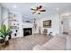 Inviting living room with built-in shelves flanking the fireplace and wood laminate floors at 62 Narmada Ct, Zebulon, NC 27597