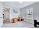 Bright room with large window, neutral walls, and carpeted floor; ideal home office space with mounted TV at 62 Narmada Ct, Zebulon, NC 27597