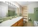 Retro bathroom features a vanity with storage, neutral countertop, and unique green tile at 704 Emory Dr, Chapel Hill, NC 27517