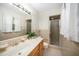 Neutral bathroom with a single sink vanity, a shower with glass door, and patterned wallpaper at 704 Emory Dr, Chapel Hill, NC 27517