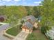 Aerial view of the house showcasing its brick facade, two-car garage, deck, and well-manicured lawn at 8000 Old Deer Trl, Raleigh, NC 27615