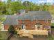 Aerial view of a brick house and its wooden deck and fenced-in backyard at 8000 Old Deer Trl, Raleigh, NC 27615