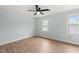 Light-filled bedroom with wood-look flooring, a ceiling fan, and windows at 8000 Old Deer Trl, Raleigh, NC 27615