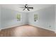 Bedroom featuring two windows that provide natural light and wood-look laminate flooring at 8000 Old Deer Trl, Raleigh, NC 27615