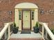Close up of the front exterior entrance with a brick facade and decorative planters at 8000 Old Deer Trl, Raleigh, NC 27615
