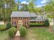 Charming two-story brick home with a well-manicured lawn and lush landscaping creating a welcoming curb appeal at 8000 Old Deer Trl, Raleigh, NC 27615