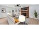 Cozy living room with a brick fireplace, built-in shelves, and French doors leading to the outdoor deck at 8000 Old Deer Trl, Raleigh, NC 27615