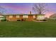 Back exterior view of a brick home featuring a large lawn and sunroom at 808 N Franklin Dr, Sanford, NC 27330