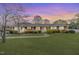 Beautiful single-story brick home with a manicured lawn and mature landscaping at dusk at 808 N Franklin Dr, Sanford, NC 27330