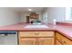 Close-up of kitchen sink area featuring wood cabinetry and red countertop at 808 N Franklin Dr, Sanford, NC 27330