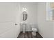 Charming powder room featuring wood-look flooring, pedestal sink and oval mirror at 825 Kenyon Spring Dr, Zebulon, NC 27597