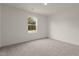 Bright bedroom with natural light streaming through a large window, plush carpeting, and neutral walls at 825 Kenyon Spring Dr, Zebulon, NC 27597