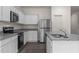 Modern kitchen featuring stainless steel appliances, white cabinets, and sleek granite countertops for a contemporary look at 825 Kenyon Spring Dr, Zebulon, NC 27597