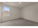 A well-lit bedroom featuring plush carpeting, fresh neutral paint, and a large window at 829 Kenyon Spring Dr, Zebulon, NC 27597
