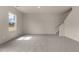 Spacious living area with plush carpeting, a window, and staircase at 829 Kenyon Spring Dr, Zebulon, NC 27597