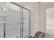 A shower with glass doors, wood look flooring, and chrome fixtures at 829 Kenyon Spring Dr, Zebulon, NC 27597