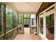 Covered porch features wood flooring, ceiling fan, and a screened-in section with peaceful wooded views at 8418 Wheatstone Ln, Raleigh, NC 27613