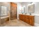 Bathroom with stone shower, soaking tub, and double sink wooden vanity at 8418 Wheatstone Ln, Raleigh, NC 27613