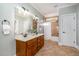 Well-lit bathroom boasts a double vanity with framed mirrors and a shower-tub combo at 8418 Wheatstone Ln, Raleigh, NC 27613