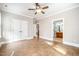 Large bedroom with neutral colors, ceiling fan, and two entry doors at 8418 Wheatstone Ln, Raleigh, NC 27613