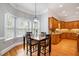 Sunny breakfast nook with black chairs, bay window and hardwood flooring at 8418 Wheatstone Ln, Raleigh, NC 27613