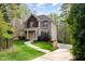 Traditional two-story home with a brick exterior, stone accents, mature landscaping, and a curved walkway at 8418 Wheatstone Ln, Raleigh, NC 27613