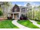 Charming two-story home featuring a stone and brick facade, complemented by a lush, landscaped front yard at 8418 Wheatstone Ln, Raleigh, NC 27613