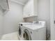 Functional laundry room with white washer and dryer and white cabinets at 8418 Wheatstone Ln, Raleigh, NC 27613