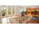 Bright living room with hardwood floors, large area rug, fireplace, and access to an outdoor deck at 8418 Wheatstone Ln, Raleigh, NC 27613