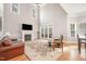 Spacious living room with vaulted ceilings, fireplace, and french doors leading to a porch at 8418 Wheatstone Ln, Raleigh, NC 27613