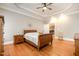 Spacious main bedroom with tray ceiling, hardwood floors, and view to kitchen area at 8418 Wheatstone Ln, Raleigh, NC 27613