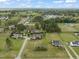 Aerial view of homes in a rural neighborhood, surrounded by mature trees and green spaces at 8437 Little Woody Ct, Zebulon, NC 27597