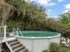 Backyard showcasing a round above-ground pool with an attached deck and ladder at 8437 Little Woody Ct, Zebulon, NC 27597