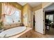 This bathroom features a soaking tub with tile surround, neutral walls, and entry to a walk-in closet at 8437 Little Woody Ct, Zebulon, NC 27597