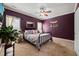 This bedroom features a metal bedframe, carpeted floor, and aubergine-colored walls with neutral trim at 8437 Little Woody Ct, Zebulon, NC 27597