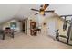 Multi-use bonus room with multiple doors, desk, and game table under a ceiling fan at 8437 Little Woody Ct, Zebulon, NC 27597