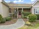 Charming front entrance with a brick facade, red door, and beautifully landscaped surroundings at 8437 Little Woody Ct, Zebulon, NC 27597