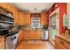 Bright kitchen featuring stainless appliances, wood cabinets, and an outdoor view at 8437 Little Woody Ct, Zebulon, NC 27597