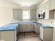 Bright kitchen with gray cabinets and a breakfast bar, waiting for final appliances at 905 Linwood Ave, Durham, NC 27701