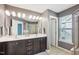 Bathroom featuring a double sink vanity, dark wood cabinets, and a glass-enclosed shower at 912 Ambergate Sta, Apex, NC 27502